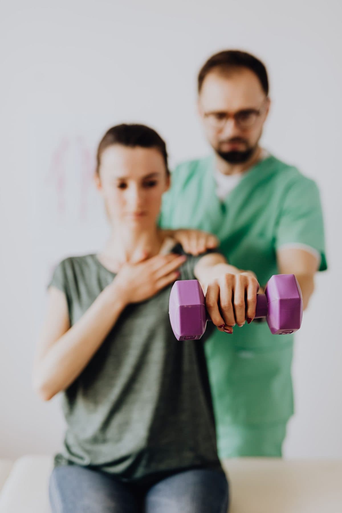 Fisioterapeuta orientando uma paciente em um exercício com halter